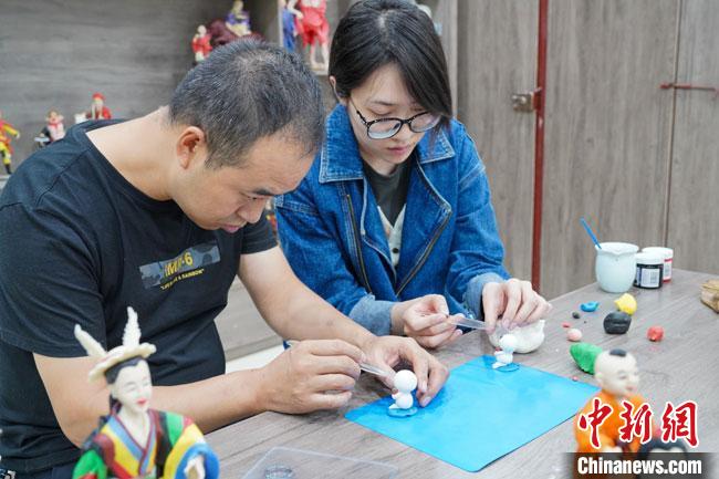 <a target='_blank'  data-cke-saved- >中新社</a>記者(右)現(xiàn)場體驗(yàn)面塑制作過程?！￡悹帍?qiáng) 攝