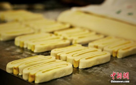 圖為面劑被涂上胡麻油，切成條狀用作月餅的花型制作。張文 攝