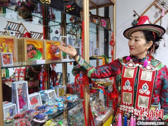 圖為身著民族服飾的隴原巧手展示手工藝品。(資料圖) 徐雪 攝