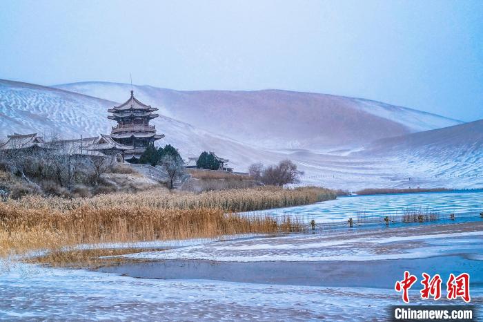2021年11月28日，雪落鳴沙山月牙泉景區(qū)?！⊥醣筱y 攝
