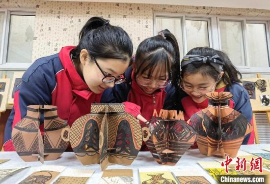 圖為學生用紙創(chuàng)作的立體彩陶?！⒂裉?攝