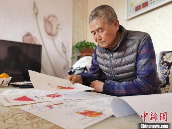 圖為陸鵬飛向記者展示多年帶隊(duì)的手寫筆記?！堟?攝