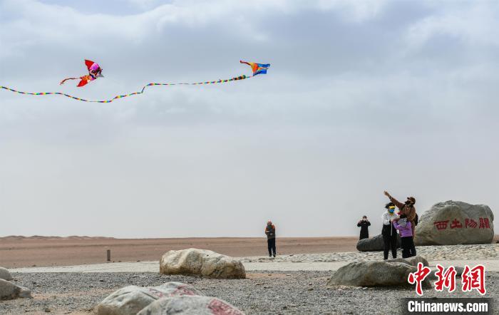 圖為市民正在陽關(guān)景區(qū)放風(fēng)箏。　王斌銀 攝