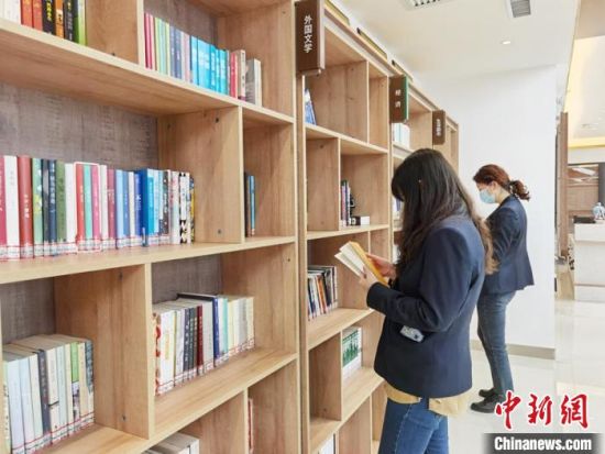 圖為在甘肅公航旅建設(shè)集團(tuán)有限公司的職工書屋，職工挑選書籍。　徐雪 攝