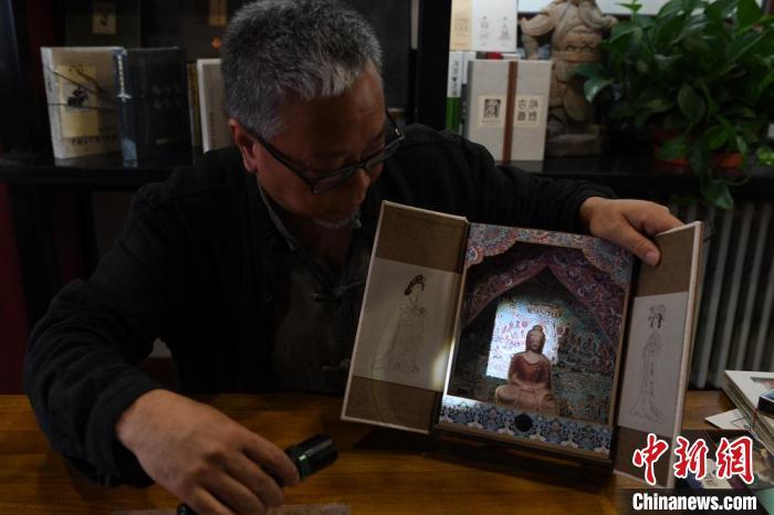 圖為讀者出版集團(tuán)讀者晉林工作室獨(dú)立出品人徐晉林，展示互動(dòng)性強(qiáng)的敦煌題材手工書(shū)。(資料圖) 楊艷敏 攝