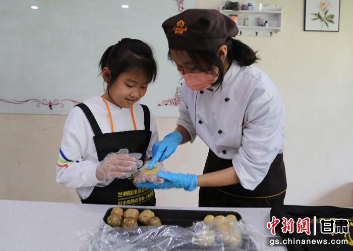 圖為在甘臺胞小朋友在工作人員指導(dǎo)下制作月餅。九美旦增 攝