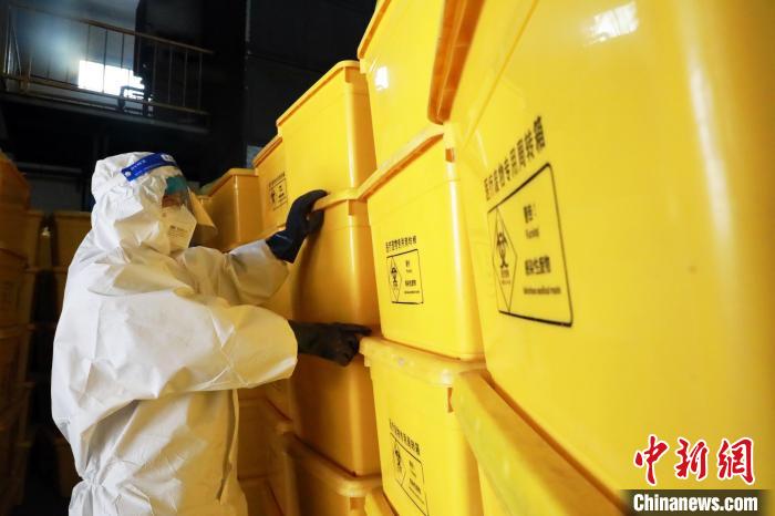 圖為工作人員搬運(yùn)醫(yī)療廢物專用周轉(zhuǎn)箱?！∥航ㄜ?攝
