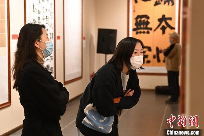 圖為甘肅蘭州，參展書(shū)法作品吸引參觀者。 中新社記者 李亞龍 攝