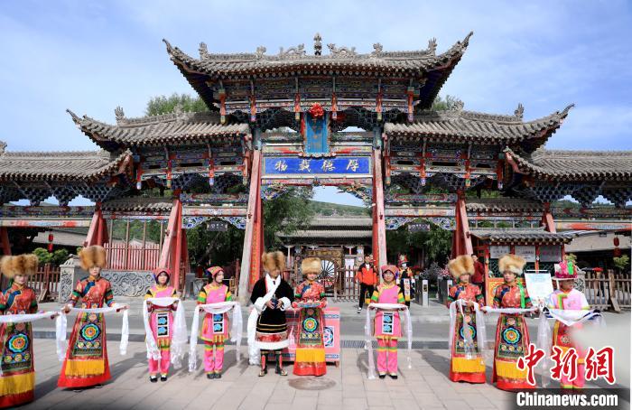 圖為身穿土族服飾的工作人員迎接訪客?！⊙Φ?攝