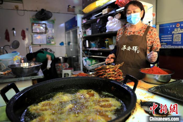 圖為平安驛·河湟民俗文化體驗(yàn)地內(nèi)的商戶炸干板魚(yú)?！⊙Φ?攝