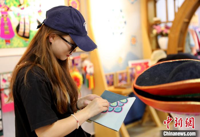 圖為民眾體驗國家級非遺項目盤繡技藝?！⊙Φ?攝