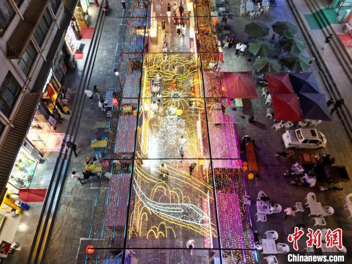 圖為明清街夜市燈光點亮具有武威文化元素的“天梯山石窟”彩燈。(無人機照片) 　戴文昌 攝</p><p>