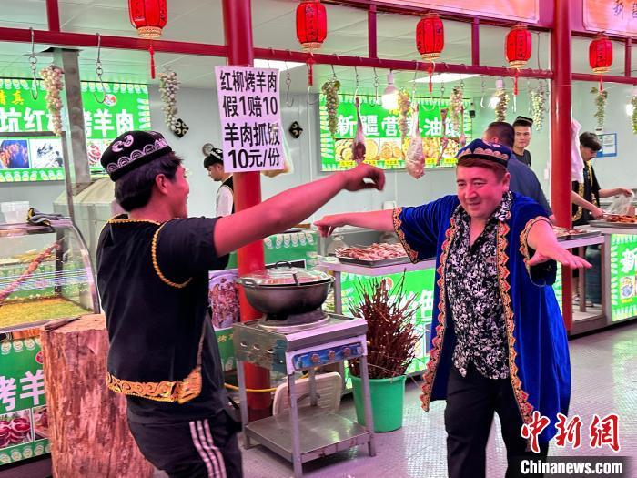 圖為餐飲經(jīng)營者在“西涼不夜城”跳起舞蹈引客?！〈魑牟?攝</p><p>