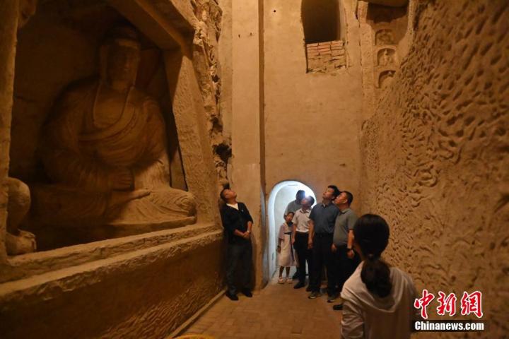 7月15日，游人參觀甘肅省平?jīng)鍪袥艽h百里石窟長廊中的王母宮石窟。百里石窟長廊位于涇川縣境內(nèi)，由512個石窟、5眼窟中石井組成，現(xiàn)存王母宮石窟、鳳凰山石窟、南石窟寺、丈八寺石窟、羅漢洞石窟、太山寺石窟等規(guī)模較大的石窟群，還有數(shù)量眾多的小石窟群。王母宮石窟又名千佛洞，該窟設(shè)計宏大，造像生動，窟內(nèi)擁有造像數(shù)百尊，是較為珍貴的佛教文化歷史遺存。中新社記者 李亞龍 攝</p>
<p>