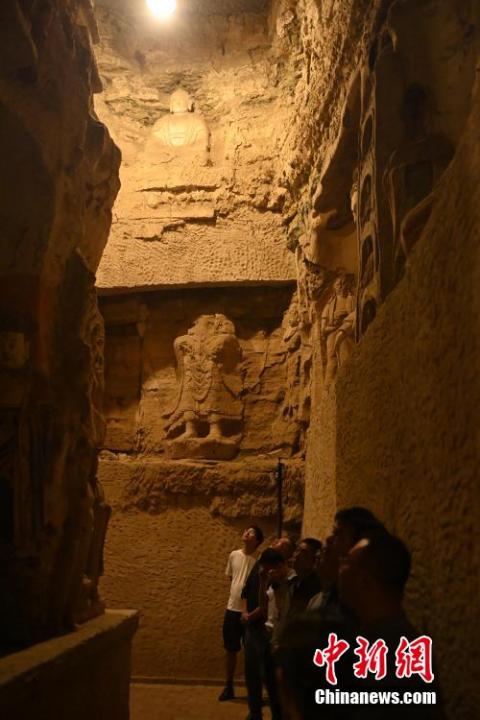 7月15日，游人參觀甘肅省平?jīng)鍪袥艽h百里石窟長廊中的王母宮石窟。百里石窟長廊位于涇川縣境內(nèi)，由512個石窟、5眼窟中石井組成，現(xiàn)存王母宮石窟、鳳凰山石窟、南石窟寺、丈八寺石窟、羅漢洞石窟、太山寺石窟等規(guī)模較大的石窟群，還有數(shù)量眾多的小石窟群。王母宮石窟又名千佛洞，該窟設(shè)計宏大，造像生動，窟內(nèi)擁有造像數(shù)百尊，是較為珍貴的佛教文化遺存。中新社記者 李亞龍 攝</p>
<p>