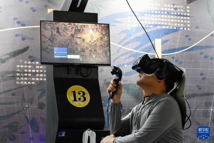 7月22日，游客借助VR設(shè)備沉浸式游覽莫高窟第285窟虛擬場景。新華社記者 郎兵兵 攝